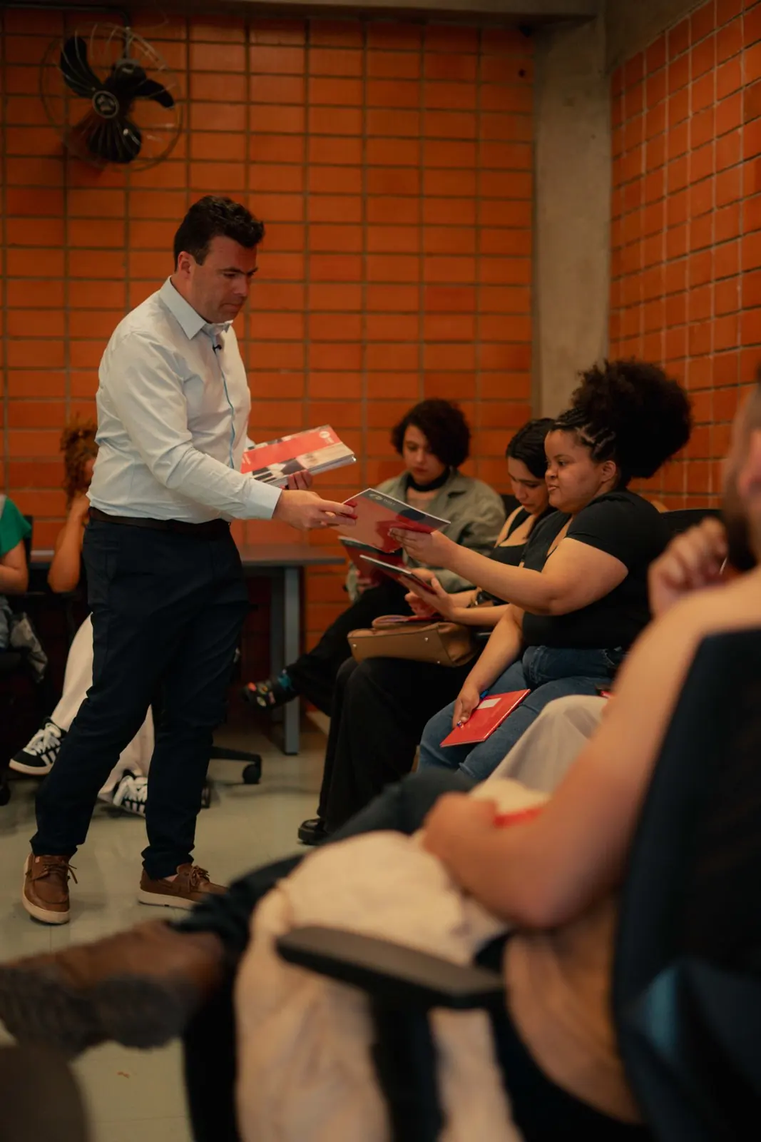 Thiago Mendes entregando o material do curso aos alunos